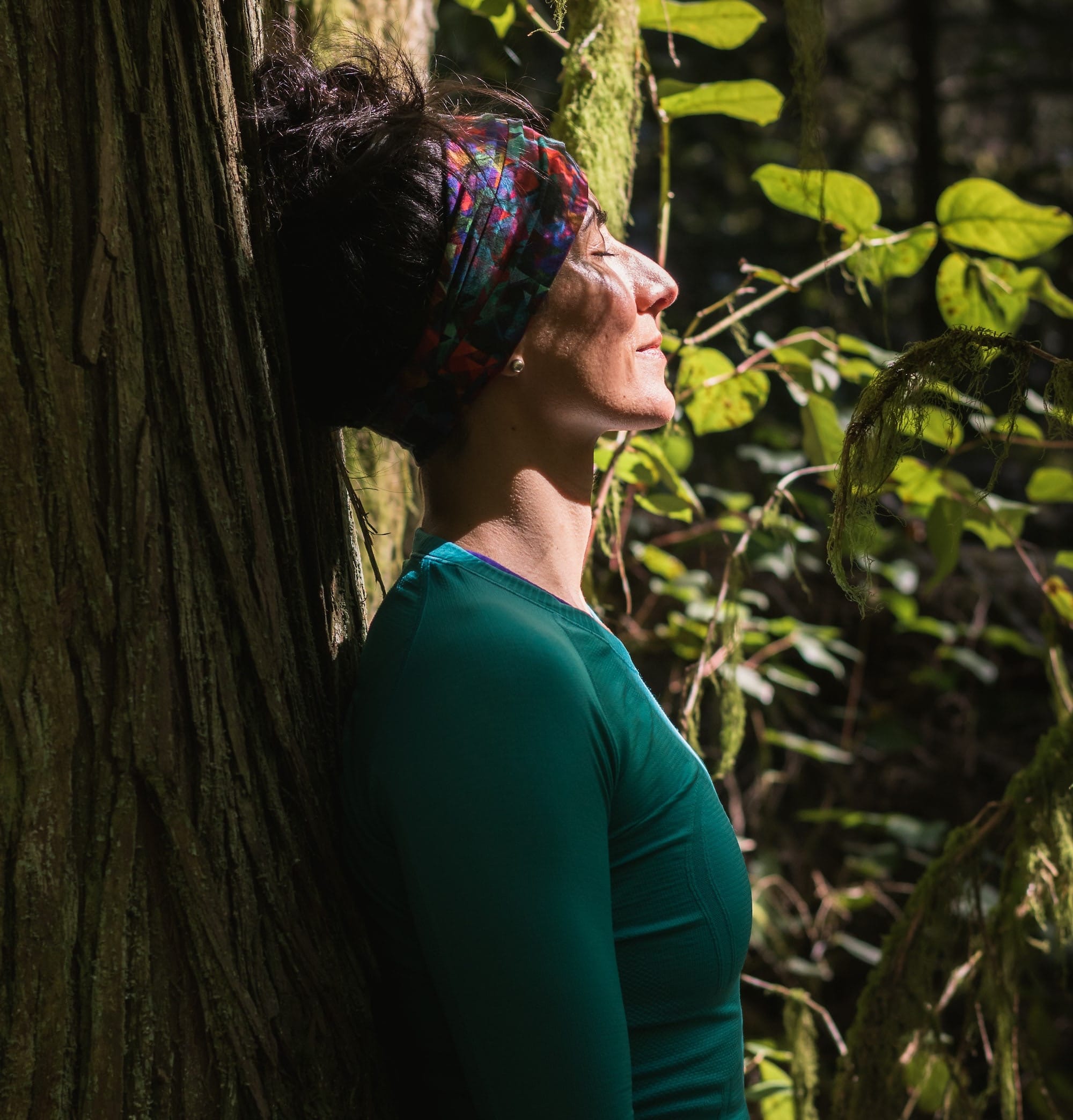 woman in green long sleeve shirt standing beside tree